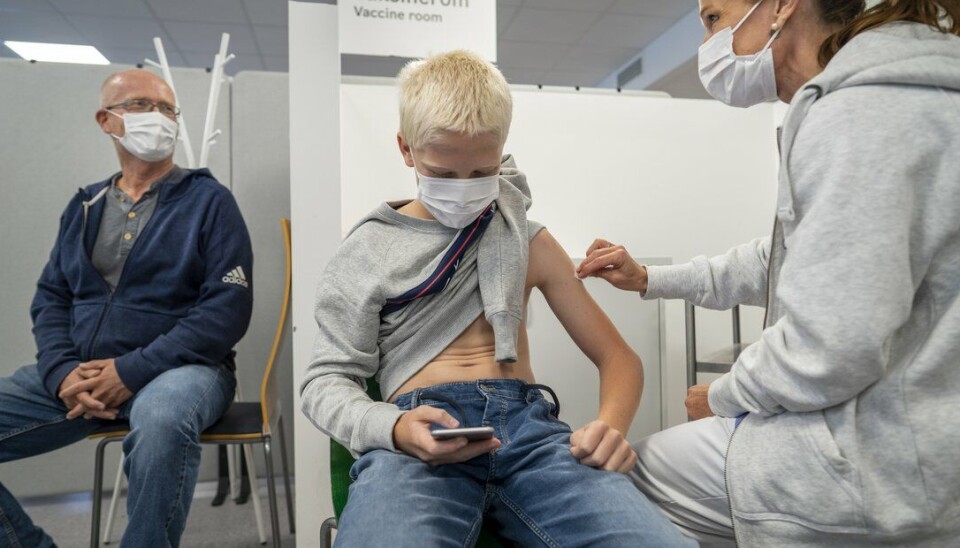 Ny forskning viser nå at beskyttelsen mot sykdom faller og aktualiserer behovet for en tredje dose med vaksine. Bildet: 13-åringen Eirik Lyngstad får første dose med Pfizer-vaksine på Bjerke vaksinesenter i Oslo mens pappa Roy Ove følger lettet med