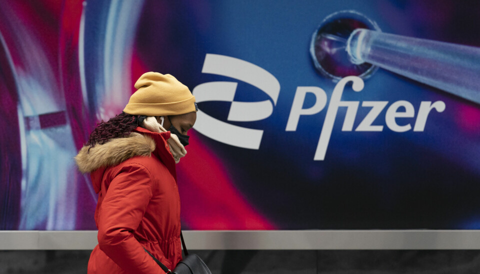 Pfizer og Seagen er i følge Wall Street Journal i oppkjøpssamtler. Bilde viser en kvinne som går forbi Pfizer hovedkvarter i New York.